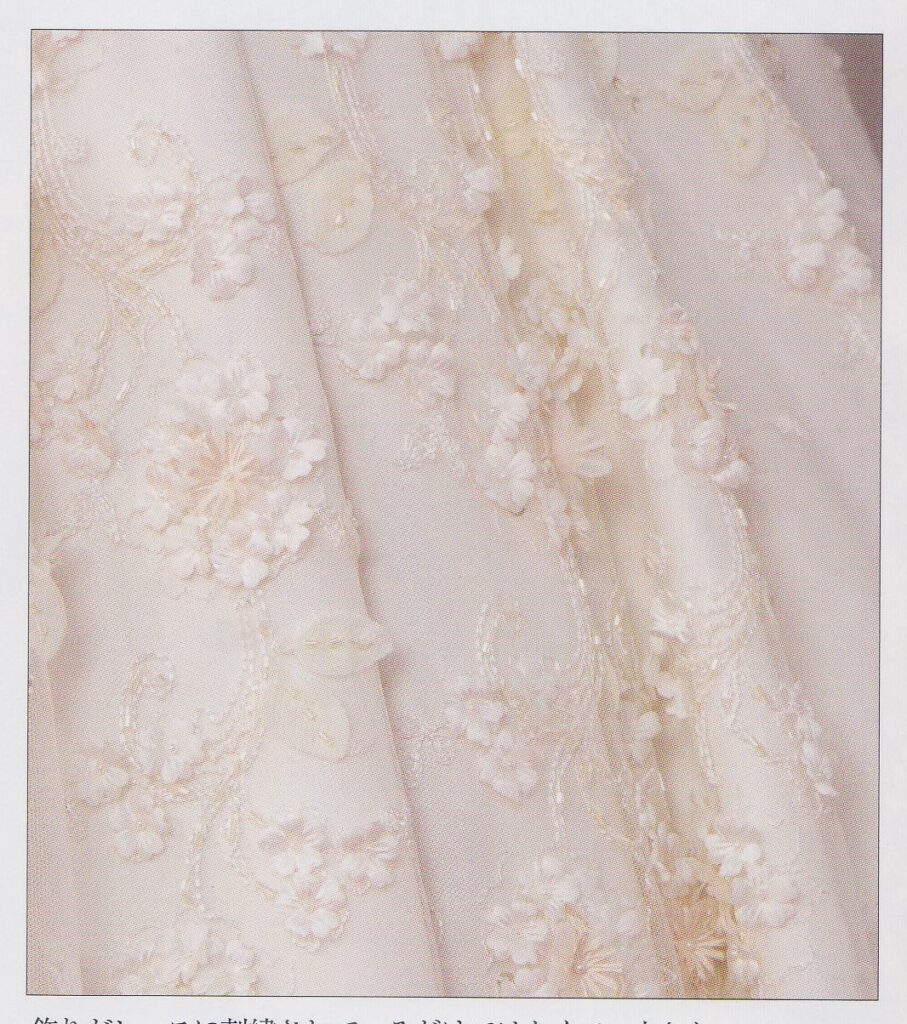 A texture closeup of Aono Yuuki's skirt. The offwhite fabric is overlayed with net and dimensional flowers.